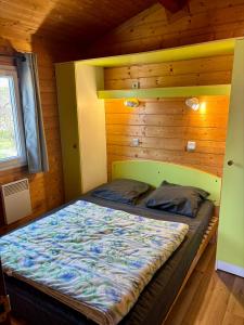 a bedroom with a bed in a wooden cabin at Camping Onlycamp Pierre & Sources in Volvic