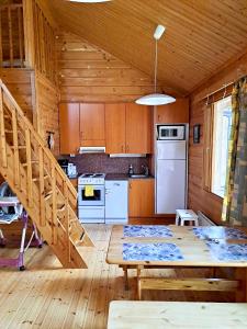 a kitchen with wooden cabinets and a table in a cabin at Holiday Home Marina in Tahkovuori
