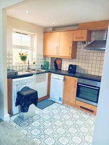 a kitchen with white appliances and a tile floor at 2 Bedrooms Flat in Surrey, 30 min to London in Woking +22 photos