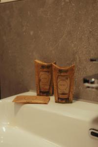 two packets of toilet paper sitting on top of a sink at Motel Q Kornspeicher in Neuruppin +30 photos