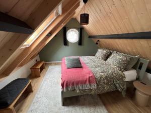 a attic bedroom with a bed and a window at Gastenverblijf Boven De S l a g e r i j in Schijndel