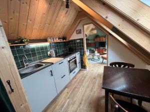 a small kitchen with a sink and a table at Gastenverblijf Boven De S l a g e r i j in Schijndel
