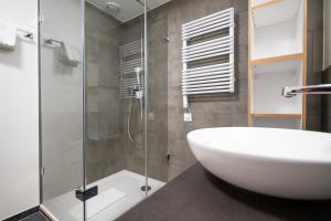 a bathroom with a sink and a glass shower at Hotel Ochsen - Self Check-in in Uster +97 photos