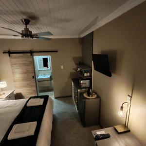 a bedroom with a bed and a couch and a tv at L'Mida in Klerksdorp