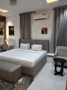 a bedroom with a bed and a couch and a chair at 5 bedroom apartment Magodo GRA in Sagisa