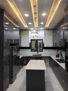 a kitchen with white cabinets and a black refrigerator at 5 bedroom apartment Magodo GRA in Sagisa