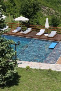 a swimming pool with lounge chairs and an umbrella at Lala Resort in Kolgecaj
