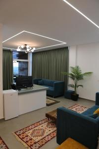 a living room with blue couches and a tv at Lala Resort in Kolgecaj