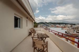 a balcony with chairs and tables on a building at Eudaimonia - Luxury Apartment in Agrinio in Agrinio