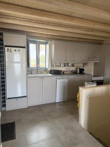 a kitchen with white cabinets and a white refrigerator at Casa Luca in Drios