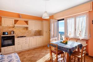 a kitchen with white cabinets and a table with chairs at Paola in Villa Faraldi
