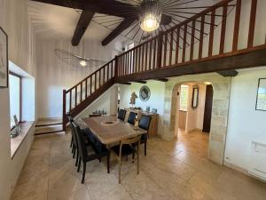 a dining room with a table and chairs and a staircase at Domaine du Soleil Couchant in Saintes-Maries-de-la-Mer