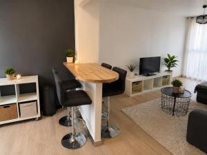 a living room with a wooden table and chairs at Le Cosy Thiers in Dunkerque