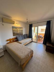 a bedroom with a bed and a couch in it at Espalmador E10, RT259PL in Es Pujols