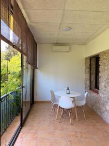 a dining room with a white table and chairs at La Sabonnera in Sant Llorenç de la Muga