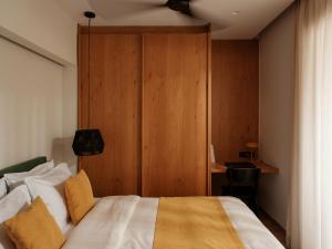 a bedroom with a bed with a wooden wall at Eudaimonia - Luxury Apartment in Agrinio in Agrinio