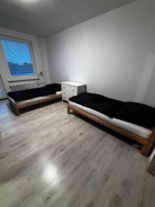 two beds in a room with wooden floors at 3 room apartment in Trnava