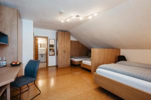 a bedroom with a bed and a desk and a chair at Hotel am Haidel in Hinterschmiding