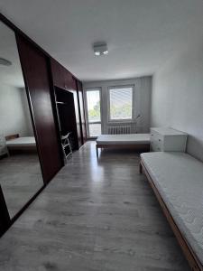 an empty room with two beds and a window at 3 room apartment in Trnava