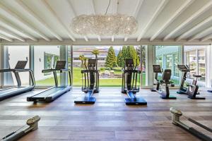 a gym with several treadmills and a chandelier at Appartement Rosalia Delta Resort 741 in Ascona