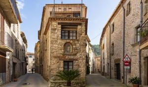an old stone building with a balcony on a street at La Sabonnera in Sant Llorenç de la Muga