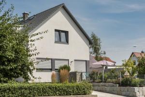 a white house with a black roof at Ferienwohnung Marla in Eriskirch