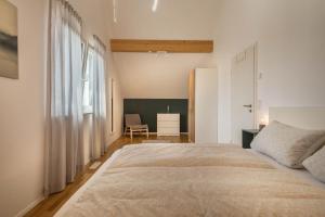 a bedroom with a large bed and a chair at Ferienwohnung Marla in Eriskirch