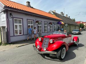 an old red car parked in front of a building at Venezia in Haapsalu
