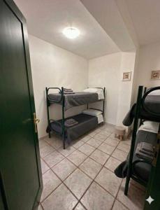 a room with bunk beds in a room with a door at Le Case dei Ginepri in Marina di Sorso