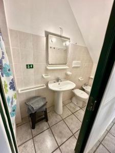 a bathroom with a sink and a toilet and a mirror at Le Case dei Ginepri in Marina di Sorso