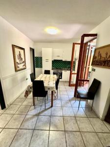 a kitchen with a table and chairs in a room at Le Case dei Ginepri in Marina di Sorso
