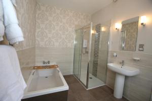 a bathroom with a shower and a sink and a tub at The Cordelia in Scarborough