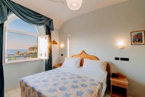 ein Schlafzimmer mit einem Bett und Meerblick in der Unterkunft Hotel Punta Imperatore in Forio d'Ischia + 32 Fotos