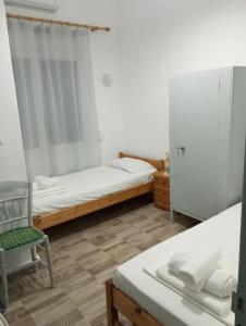 a bedroom with a bed and a chair and a window at Δωμάτια Σοφία in Agios Kirykos
