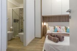 a bedroom with two beds and a bathroom with a tub at NURAS - DomoDé in Alghero +16 photos