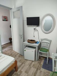 a room with a table and a chair and a mirror at Δωμάτια Σοφία in Agios Kirykos
