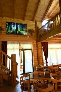 a dining room with a table and chairs and a tv at Eco Lux Prokletije resort in Gusinje