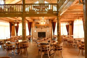 a restaurant with tables and chairs and a fireplace at Eco Lux Prokletije resort in Gusinje