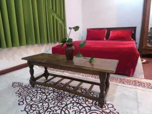 a room with a bed and a table with a red bed at Miracle holiday homestay in Demodera