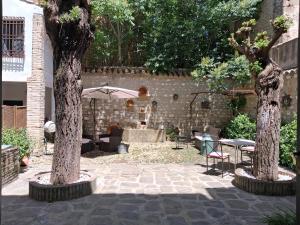 a patio with two trees and a table and chairs at Hotel Ordóñez Sandoval in Úbeda