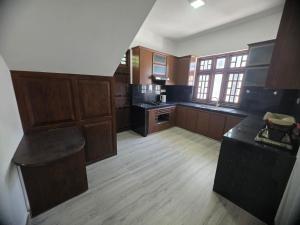a large kitchen with wooden cabinets and a counter top at Villa at 37 in Badulla