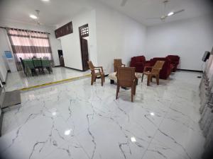 a lobby with a marble floor with chairs and tables at Villa at 37 in Badulla