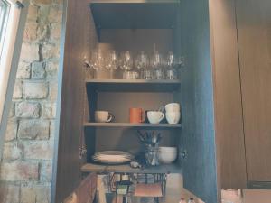 a cupboard filled with glasses and plates and bowls at Kipsala Cozy Apartment in Riga
