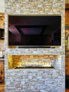a stone fireplace with a tv on top of it at Le Jardin de Freya - Balnéo - Centre historique in Auch