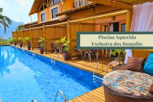 a hotel with a swimming pool in front of a building at Tahaa Pousada Boutique in Ilhabela