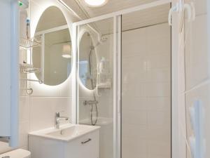 a white bathroom with a shower and a sink at La Cabane chic des Embruns in Cabourg