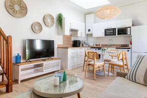 a living room with a couch and a table with a tv at La Cabane chic des Embruns in Cabourg +22 photos