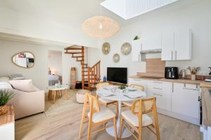 a kitchen and living room with a table and chairs at La Cabane chic des Embruns in Cabourg