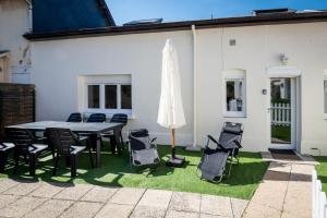a patio with a table and chairs and an umbrella at La Cabane chic des Embruns in Cabourg