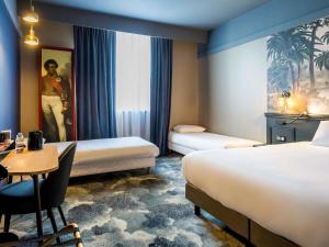 a hotel room with two beds and a table at Hôtel Mercure Rochefort La Corderie Royale in Rochefort +102 photos